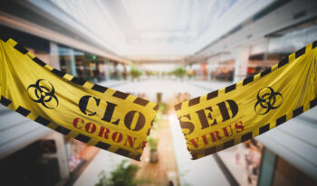 End of coronavirus COVID-19 economic lockdown. Cutting and tearing caution tape at shopping mall. Easing restrictions