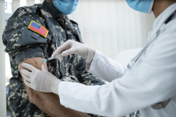 American soldier getting vaccine shot during corona virus pandemic. Military vaccination and immunization.