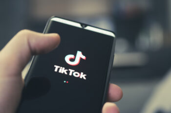 The logo of Tik Tok - a popular application for watching videos on a black smartphone. Barnaul. Russia. February 4, 2021