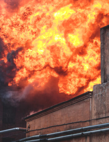 Massive large blaze fire in the city, brick factory building on fire, hell major fire explosion flame blast,  with firefighters team firemen on duty, arson, burning house destruction