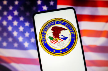 November 13, 2022, Brazil. In this photo illustration, the United States Department of Justice (DOJ) logo is displayed on a smartphone screen with a United States flag in the background