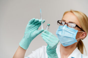 health medical worker woman holding vaccine and syringe.